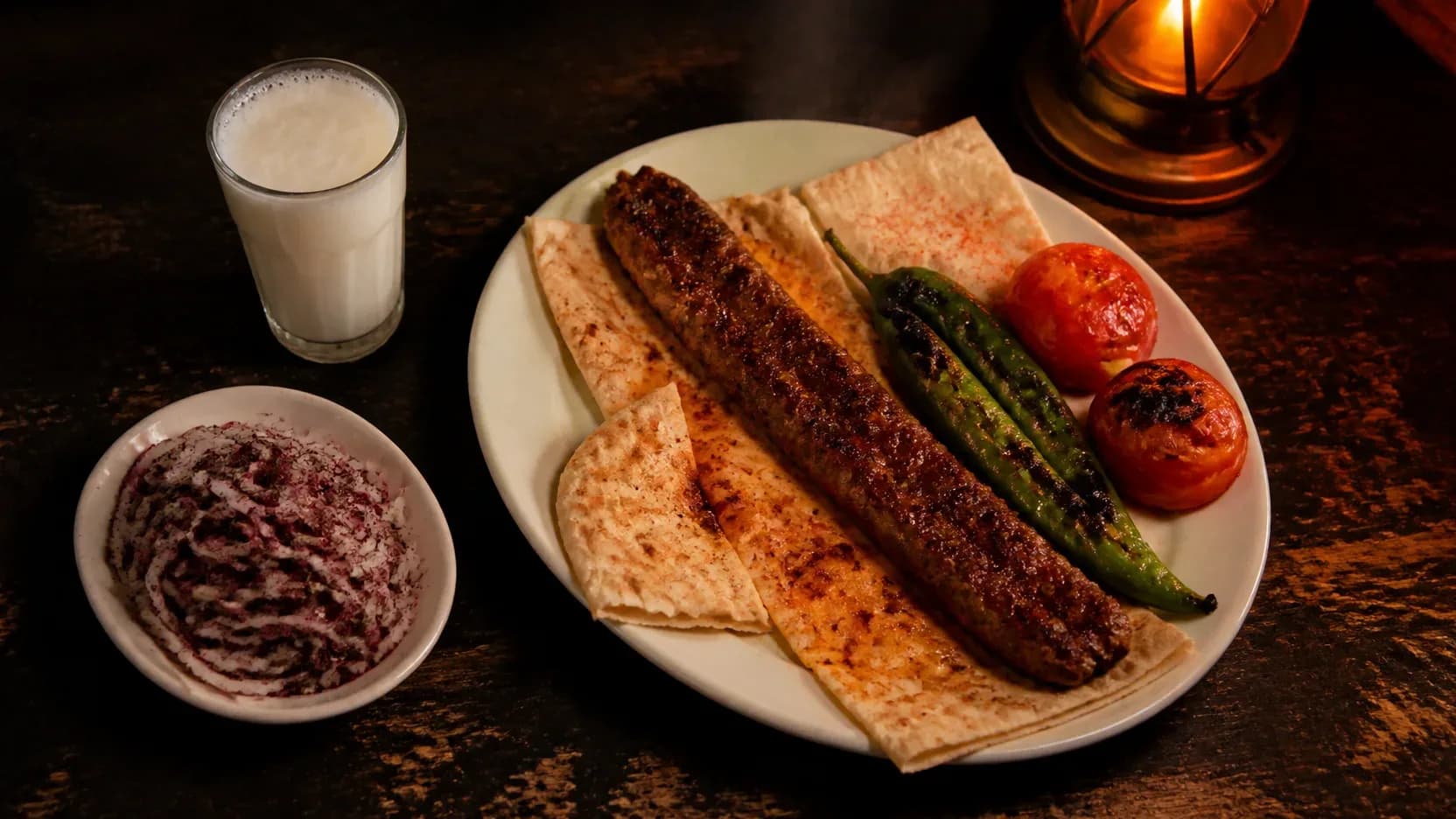 Koyu ahşap masada kurulmuş kebap sofrası